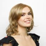 Elegant woman with blonde wig from Hidden Secrets Wigs, showcasing natural style.