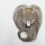 Gray wig hairpiece with lace base and clips for attachment.