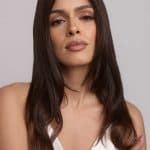 Elegant woman with long, wavy brown wig from Hidden Secrets Wigs.