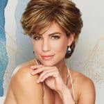 Beautiful woman with short, wavy, layered wig in warm brown tones.