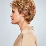 Short curly wig for women with layered, textured style and warm blonde highlights.