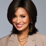 Beautiful woman with a sleek brown bob wig, smiling confidently.
