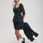 Fashion model with platinum blonde wig in a stylish black outfit.