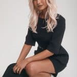 Stylish woman with platinum blonde wavy wig from Hidden Secrets Wigs.