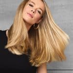 Beautiful woman with long, shiny blonde hair showcasing Hidden Secrets Wigs.