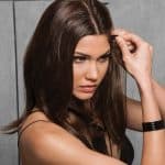 Woman styling long, straight human hair extensions with a comb.