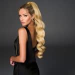 Blonde Hollywood Waves Cinch Pony wig on a model with a black dress.