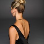 Elegant woman with Hollywood waves cinch pony hairstyle and gold jewelry.