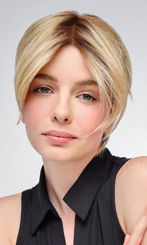 Blonde woman with short layered wig, natural look, on white background.