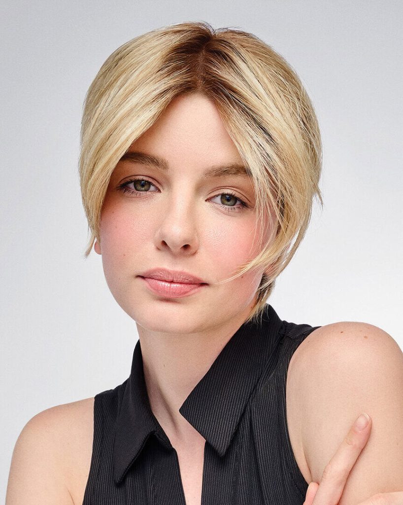 Blonde woman with short layered wig, natural look, on white background.
