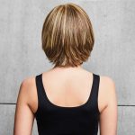 Short layered bob wig with blonde highlights on a woman from behind.