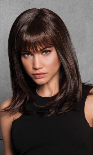 Woman with long layered dark brown wig and bangs, looking at camera.