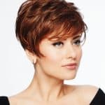 Stylish short red wig on a woman with a side-swept bang and layered cut.