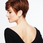 Short auburn red pixie wig styled on a woman with side profile view.