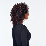 Curly wig with reddish-brown highlights on a woman in profile.