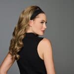 Woman with soft curled hair wearing a black headband.