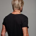 Back view of a man with a short, layered blonde wig.