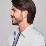 Side profile of a man with a sleek, dark brown wig and well-groomed beard.