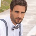 Handsome man with dark hair and beard wearing a bow tie and suspenders.