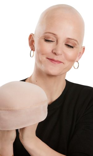Woman with a bald head wearing a beige soft lift hat from Hidden Secrets Wigs.