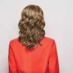 Wavy blonde headband wig styled on a woman in a red blazer.