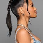 Elegant woman with sleek high ponytail and curled hair, showcasing Hidden Secrets Wigs style.