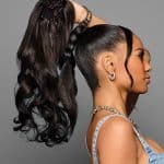 Elegant woman with sleek high ponytail and luxurious curls with claw clip.