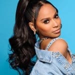 Model with long, voluminous black curls in a high ponytail.