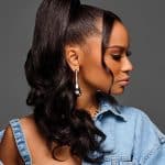 Elegant woman with long, curly hair styled in a high ponytail with a claw clip.