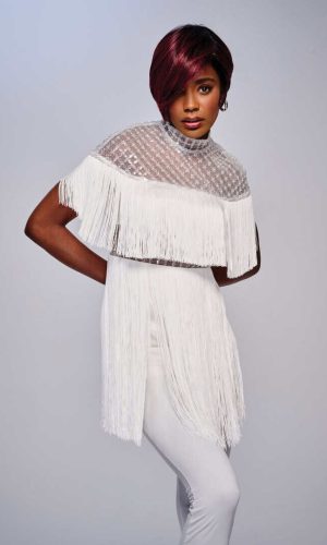 Woman with short burgundy wig and white dress, studio shot.