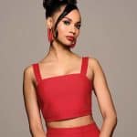 Elegant woman with a high bun hairstyle and red outfit.