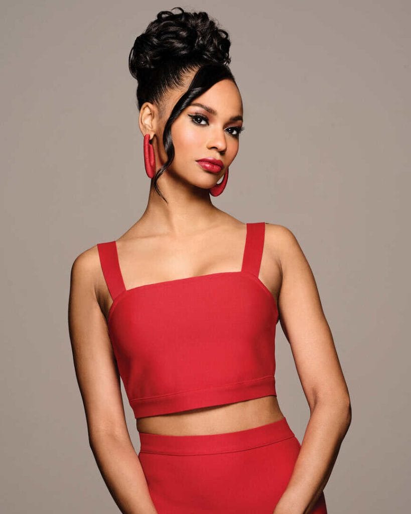 Elegant woman with a high bun hairstyle and red outfit.