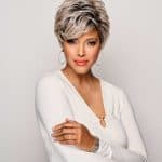 Elegant short gray wig on a woman with short hair and hoop earrings.
