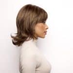 Side view of a woman wearing a brown layered wig from Hidden Secrets Wigs.