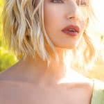 Blonde wavy wig model showcasing Hidden Secrets Wigs Liana style.