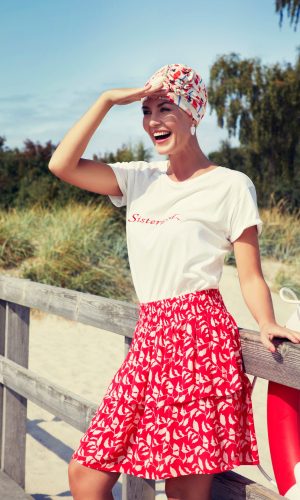 Woman wearing a colorful turban and summer outfit outdoors.