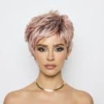 Fashion model with short pink wig and elegant makeup for a stylish look.