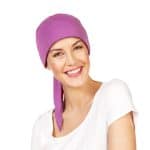 Woman wearing a purple Maha Short Scarf with a white top, smiling.