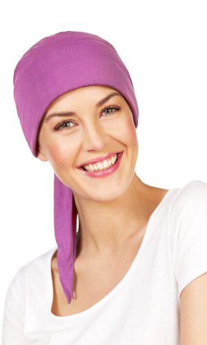 Woman wearing a purple Maha Short Scarf with a white top, smiling.