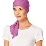 Pink short scarf styled as a head wrap on a woman.