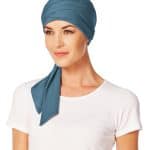 Woman wearing a blue short scarf styled as a head wrap.