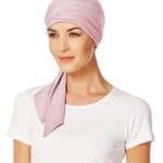 Woman wearing a pink short scarf with a white top, stylish and comfortable.