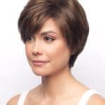 Short brown wig styled on a woman with side-swept bangs.