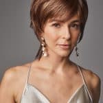 Woman with short layered brown wig and elegant silver dress.