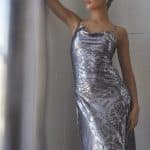 Woman wearing a stylish silver wig with a silver dress in a modern setting.