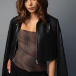 Fashionable woman with wavy brown wig and black leather jacket.