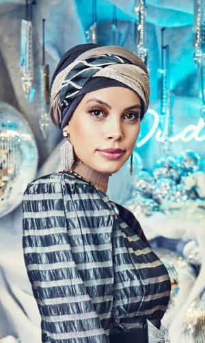 Woman wearing a stylish boho turban with striped pattern and makeup.