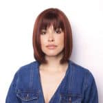 Petite Portia wig with auburn hair and bangs, styled in a sleek bob.