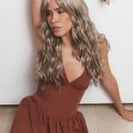 Stylish woman with long wavy blonde wig from Hidden Secrets Wigs.