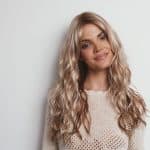 Beautiful woman with long, wavy blonde wig from Hidden Secrets Wigs.